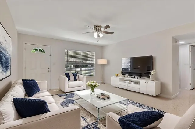 a living room with furniture a flat screen tv and a large window