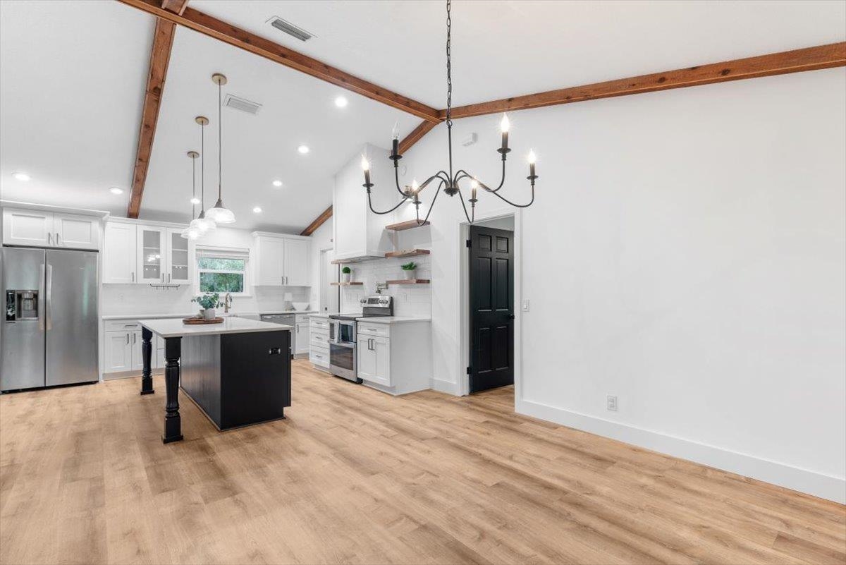 4575 Carter Road St. Augustine, FL 32086 - Photo 26 of 90 a large kitchen with stainless steel appliances kitchen island granite countertop a refrigerator a oven a stove and a sink with wooden floor