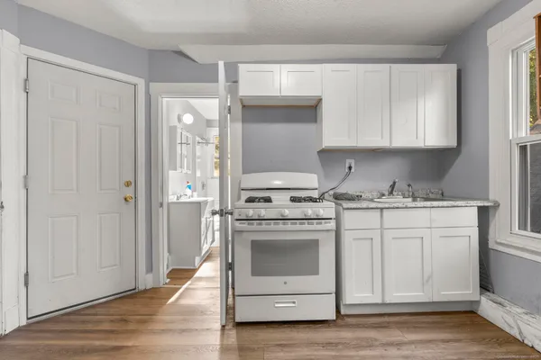 a kitchen with cabinets stainless steel appliances and a window