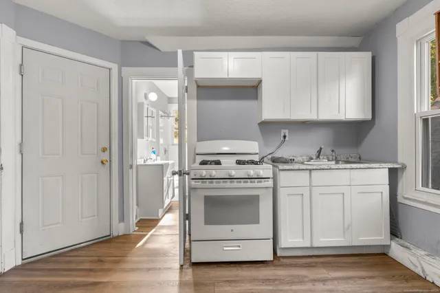 a kitchen with cabinets stainless steel appliances and a window