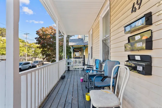 a view of a balcony with chairs and a potted plant