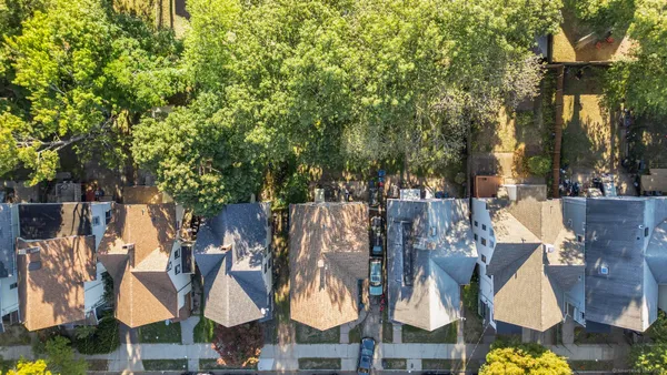an aerial view of residential house with outdoor space and trees all around