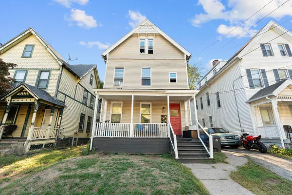 a view of a white house with large windows and a yard