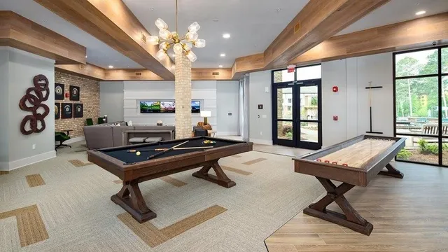 a living room with a piano table and a large window