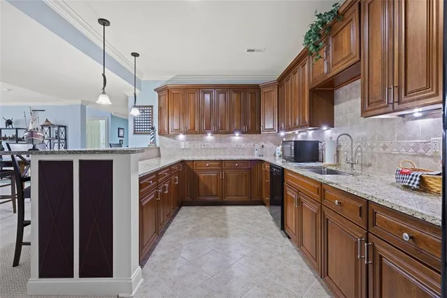 a kitchen with stainless steel appliances granite countertop a sink a stove top oven a counter space and cabinets