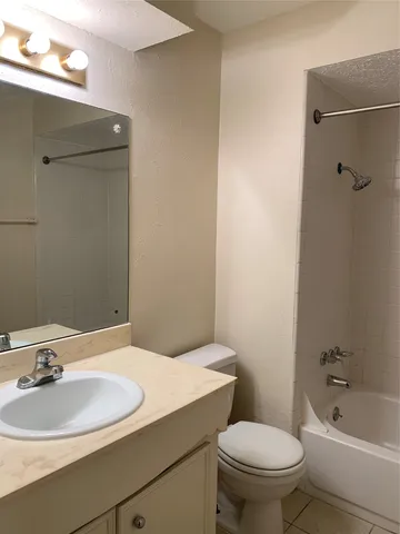a bathroom with a granite countertop toilet and a sink