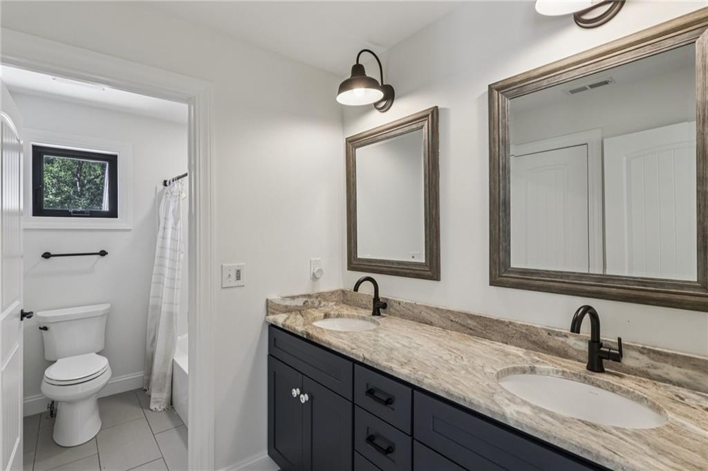 1565 Neville Road Beaver, PA 15009 - Photo 28 of 50 a bathroom with a granite countertop toilet sink and mirror