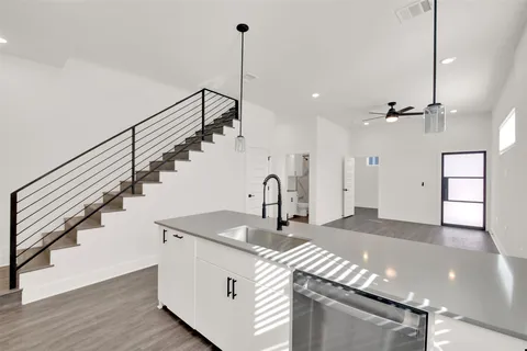 a kitchen with kitchen island a counter top a stove and a wooden floor