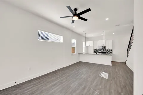 a view of a kitchen with wooden floor and a ceiling fan