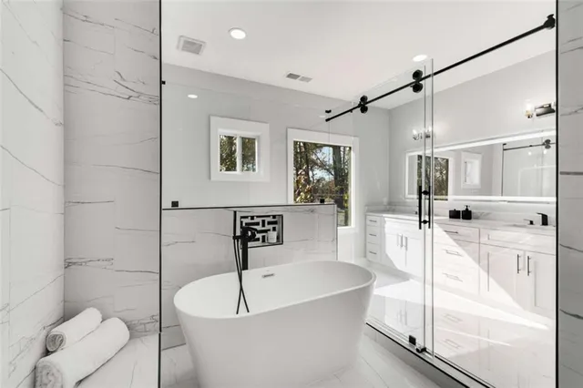 a bathroom with a tub a toilet and a shower