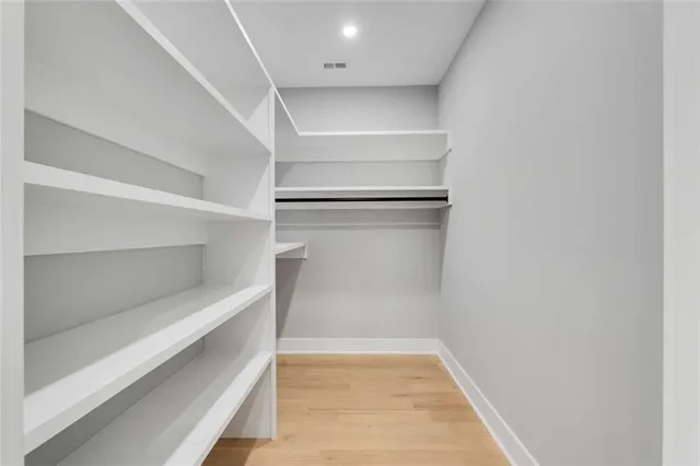 a view of walk in closet with empty racks