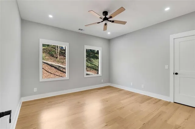 an empty room with a window and a ceiling fan