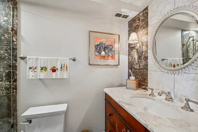 a bathroom with a granite countertop sink mirror and toilet