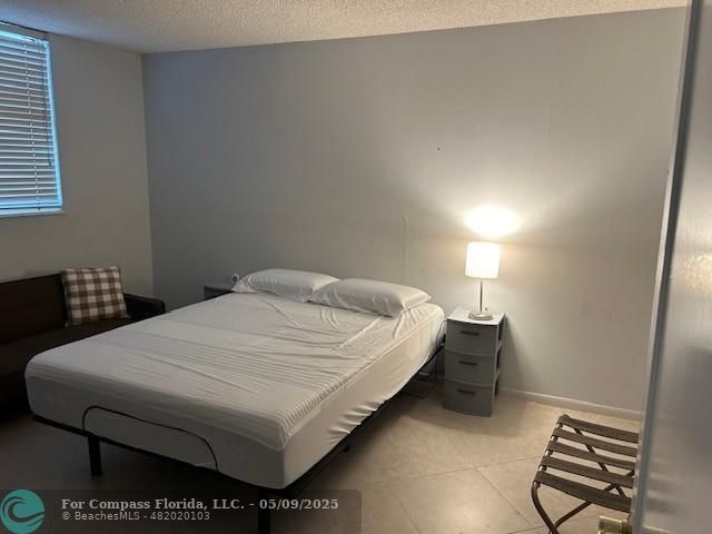 2731 Northeast 14th Street Causeway, Unit 612 Pompano Beach, FL 33062 - Photo 13 of 22 a bed sitting in a bedroom next to a lamp