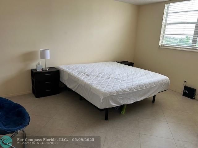 2731 Northeast 14th Street Causeway, Unit 612 Pompano Beach, FL 33062 - Photo 10 of 22 a bed sitting in a bedroom next to a window