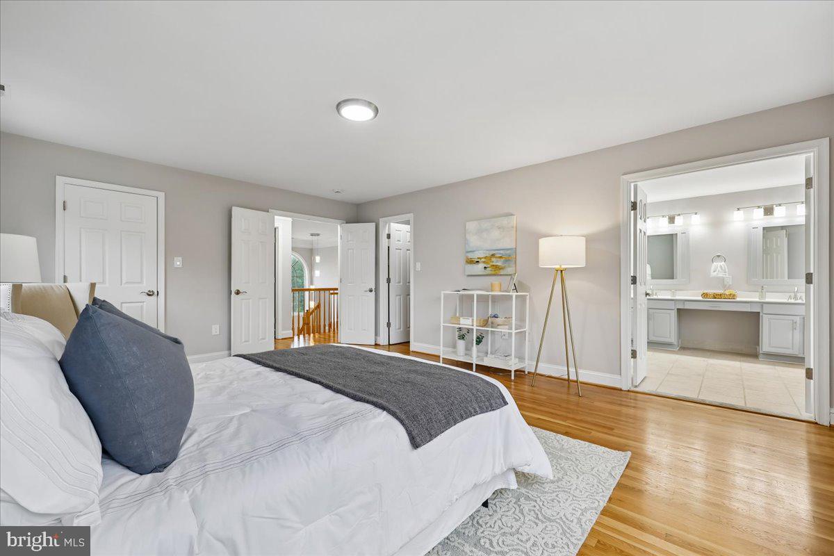 21712 Slidell Road Boyds, MD 20841 - Photo 28 of 32 a spacious bedroom with a bed a mirror and lamp