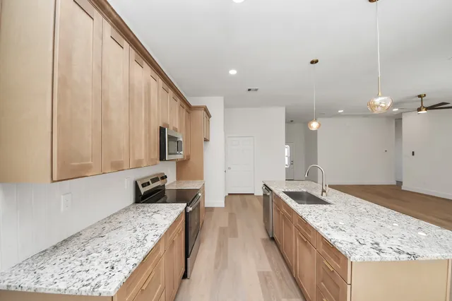 a kitchen with stainless steel appliances granite countertop a stove a microwave and a refrigerator