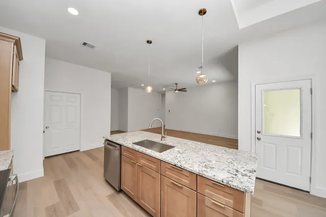 a large kitchen with kitchen island a sink stainless steel appliances and a counter space