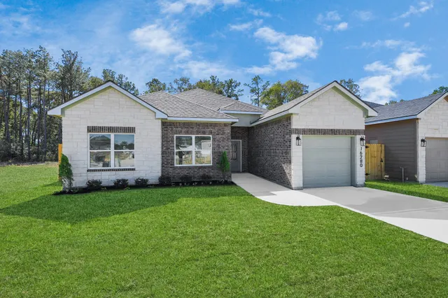 a front view of a house with a garden and yard