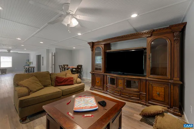 a view of a house with a small yard and large trees