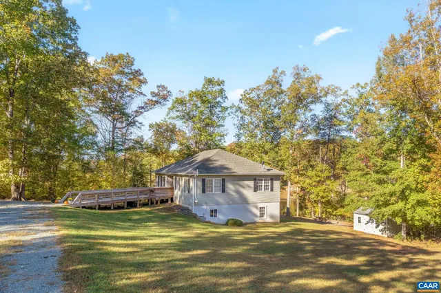 an aerial view of residential houses with outdoor space and trees