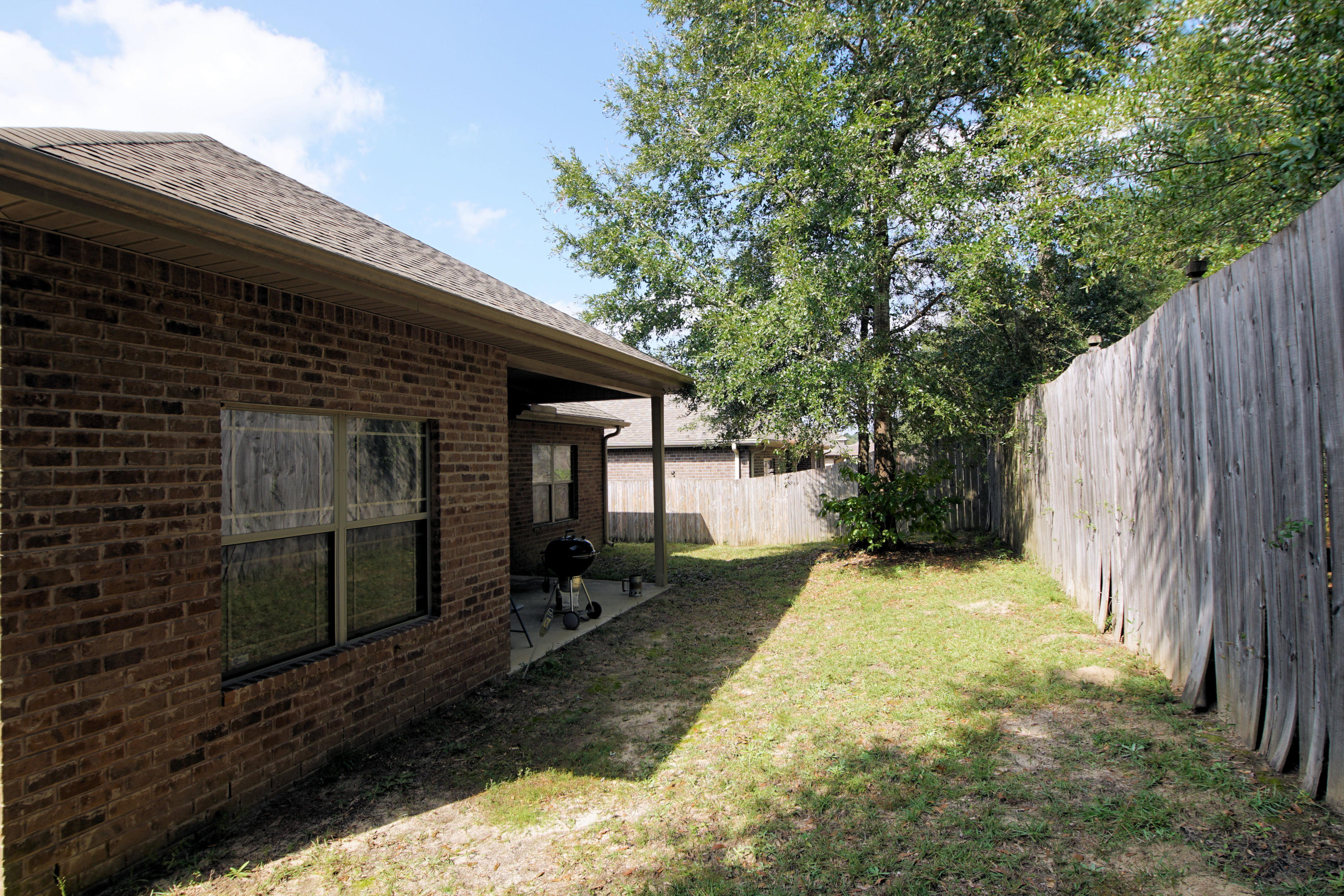 4628 Hermosa Road Crestview, FL 32539 - Photo 39 of 40 a view of backyard with wooden fence and a large tree