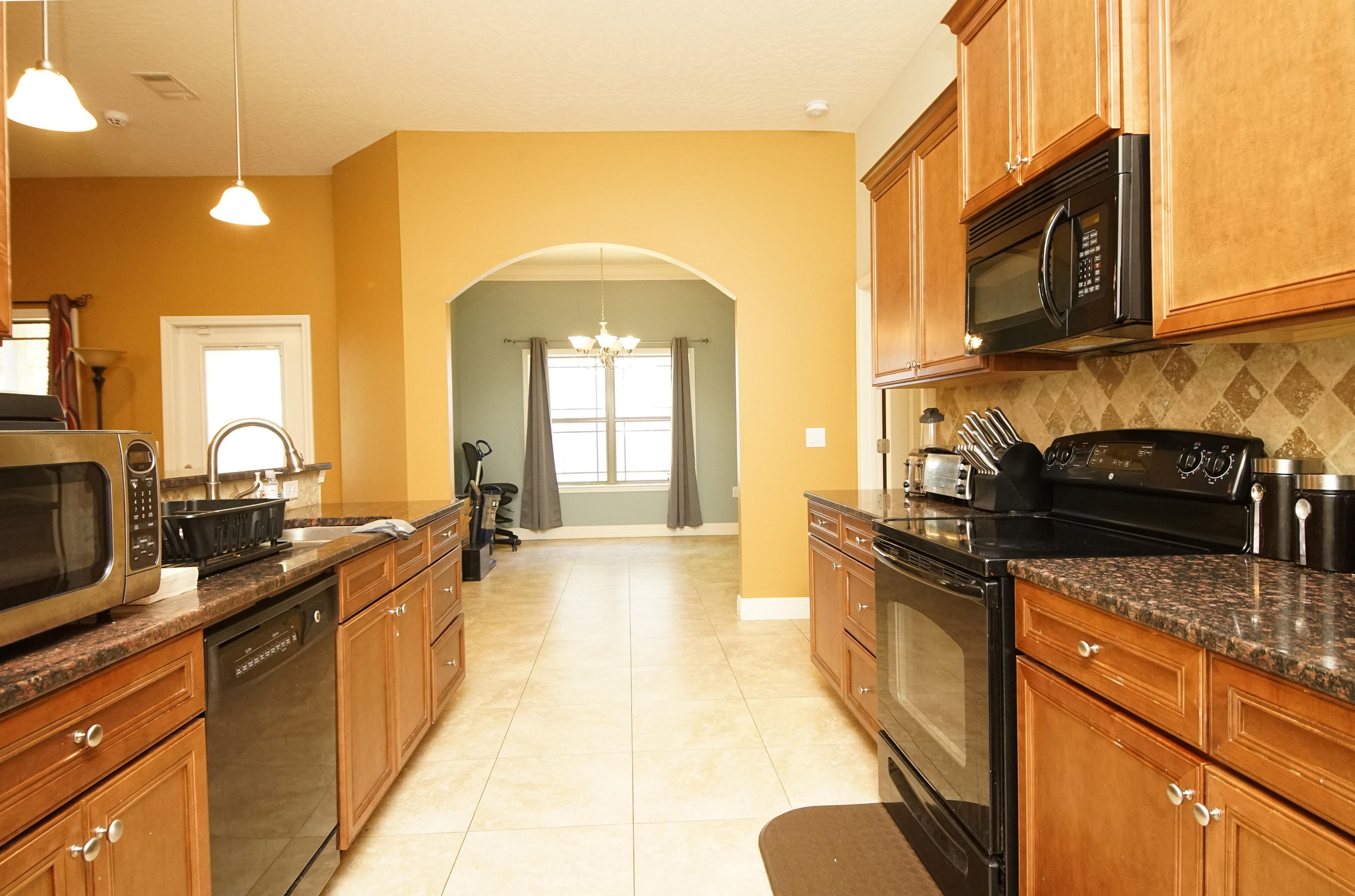 4628 Hermosa Road Crestview, FL 32539 - Photo 8 of 40 a kitchen with stainless steel appliances granite countertop a stove a sink and a microwave