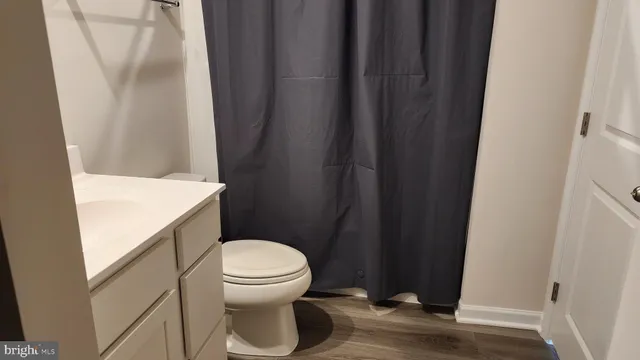 a white toilet sitting next to a shower