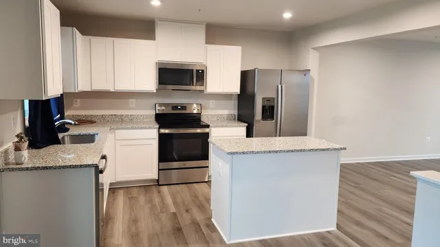 a kitchen with a sink a microwave a refrigerator and cabinets