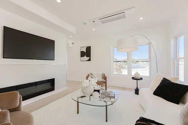 a living room with furniture a flat screen tv and a large window