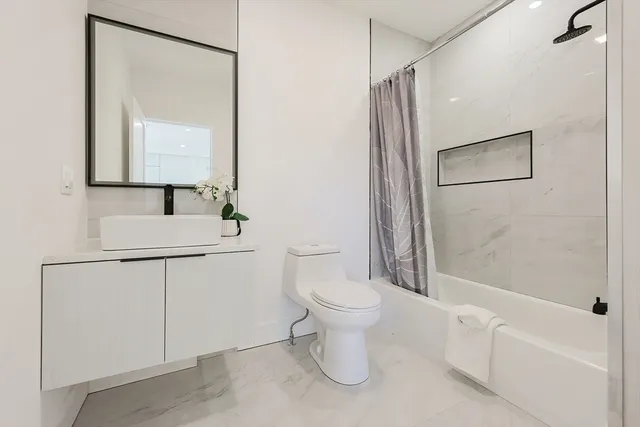 a bathroom with a toilet sink and mirror