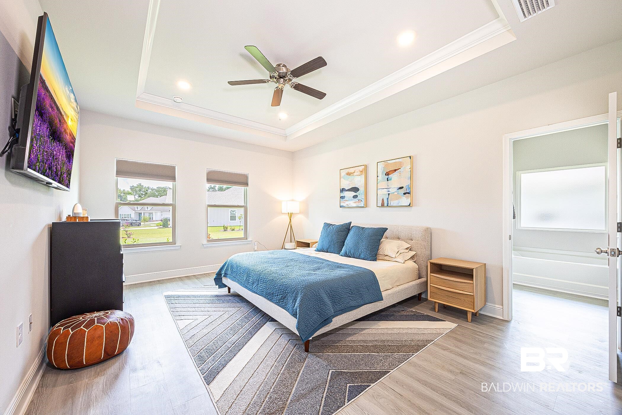 11044 Native Dancer Way Daphne, AL 36526 - Photo 16 of 67 Bedroom featuring ceiling fan, crown molding, a tray ceiling, and hardwood / wood-style floors