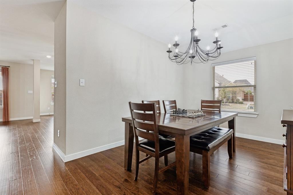 4136 Lightstone Lane Celina, TX 75009 - Photo 11 of 39 a view of a dining room with wooden floor a chandelier a wooden table and chairs