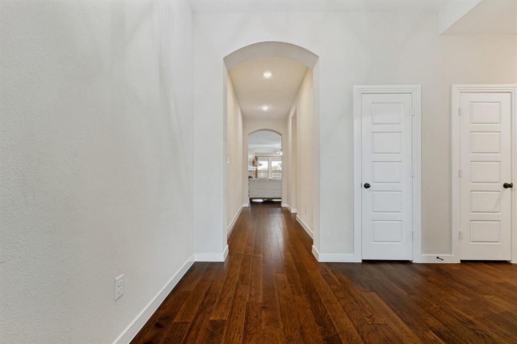 4136 Lightstone Lane Celina, TX 75009 - Photo 19 of 39 a view of a room with wooden floor and a ceiling fan