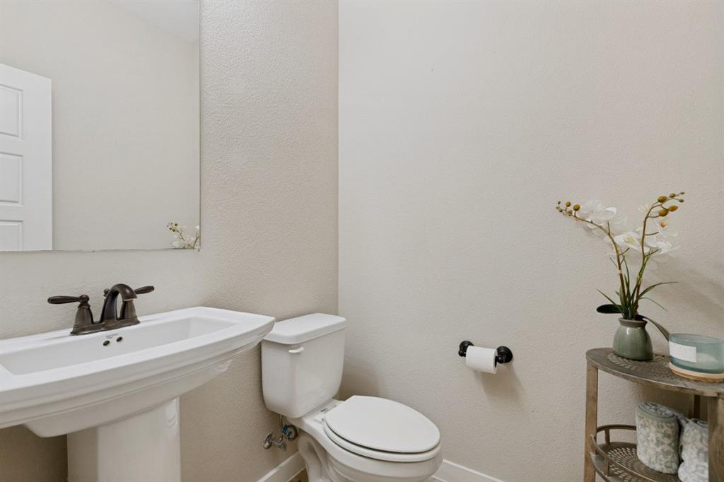 4136 Lightstone Lane Celina, TX 75009 - Photo 27 of 39 a bathroom with a sink a toilet and a mirror