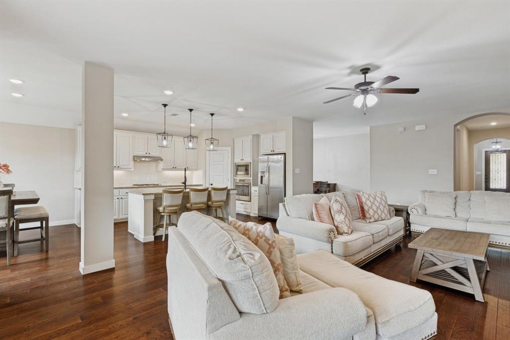 4136 Lightstone Lane Celina, TX 75009 - Photo 4 of 39 a living room with furniture a ceiling fan and a rug