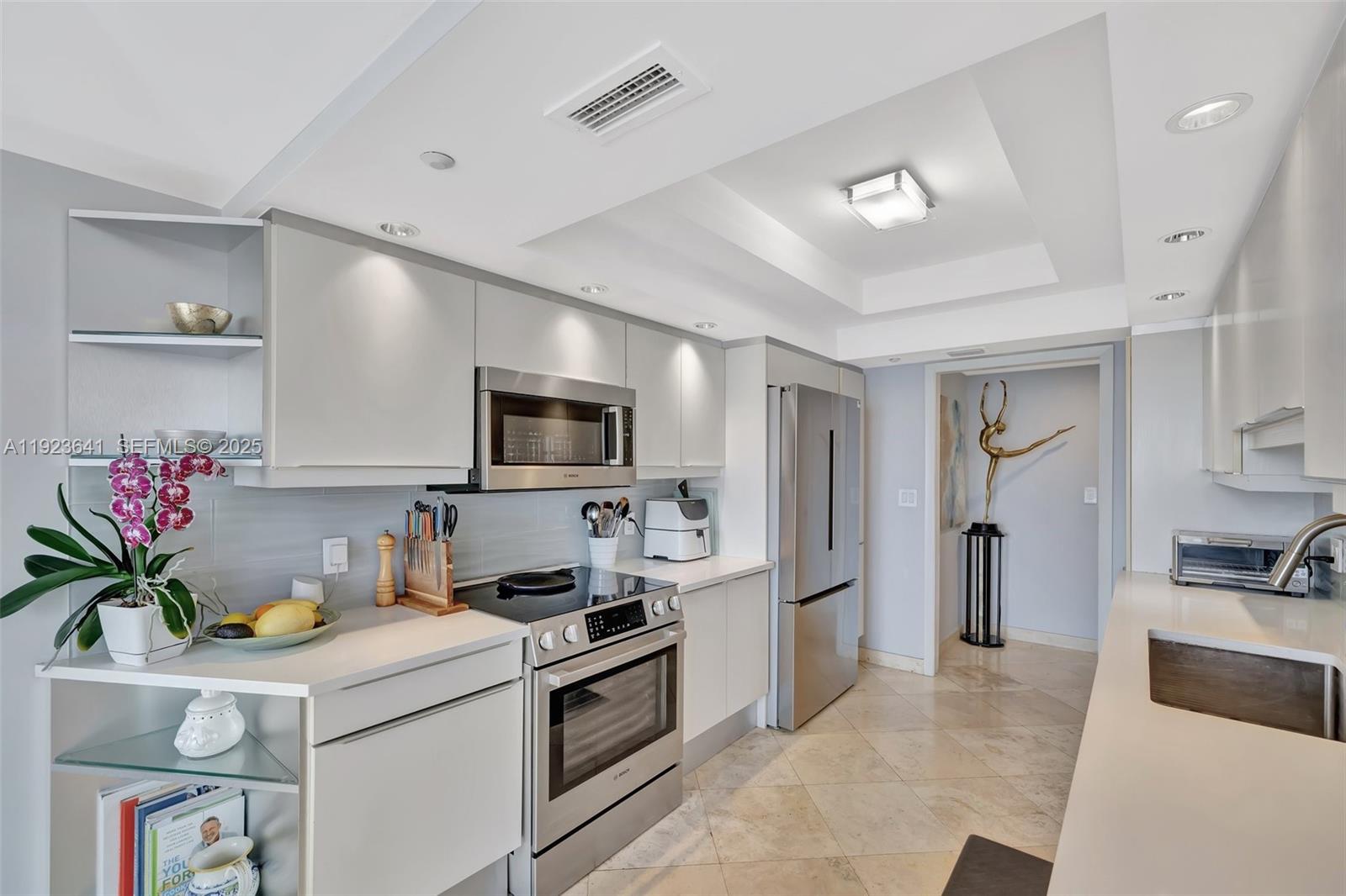 7000 Island Boulevard, Unit 1701 Aventura, FL 33160 - Photo 11 of 65 a kitchen with a sink dishwasher stove and refrigerator with wooden floor