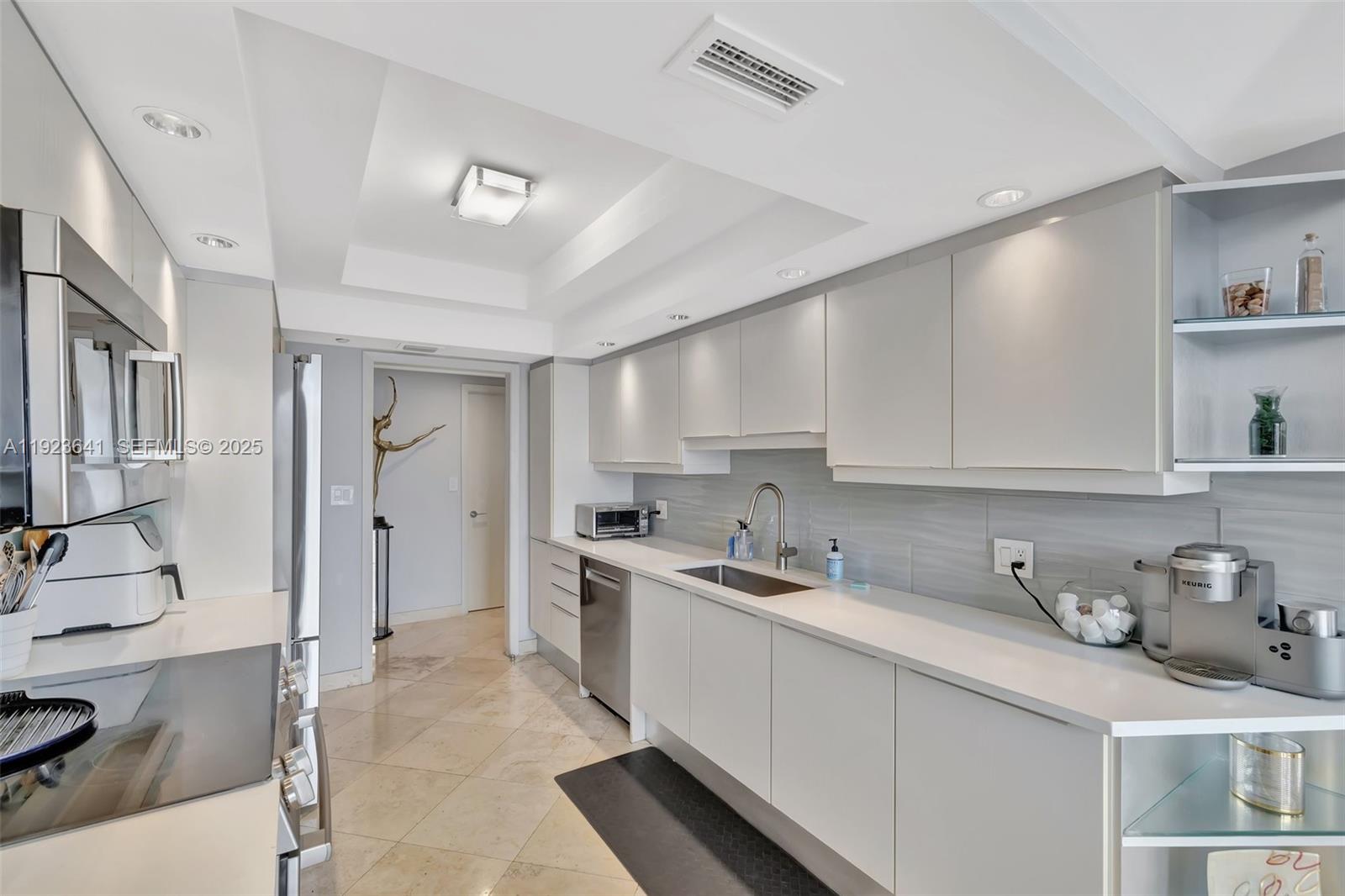 7000 Island Boulevard, Unit 1701 Aventura, FL 33160 - Photo 12 of 65 a kitchen with stainless steel appliances granite countertop a sink stove and cabinets