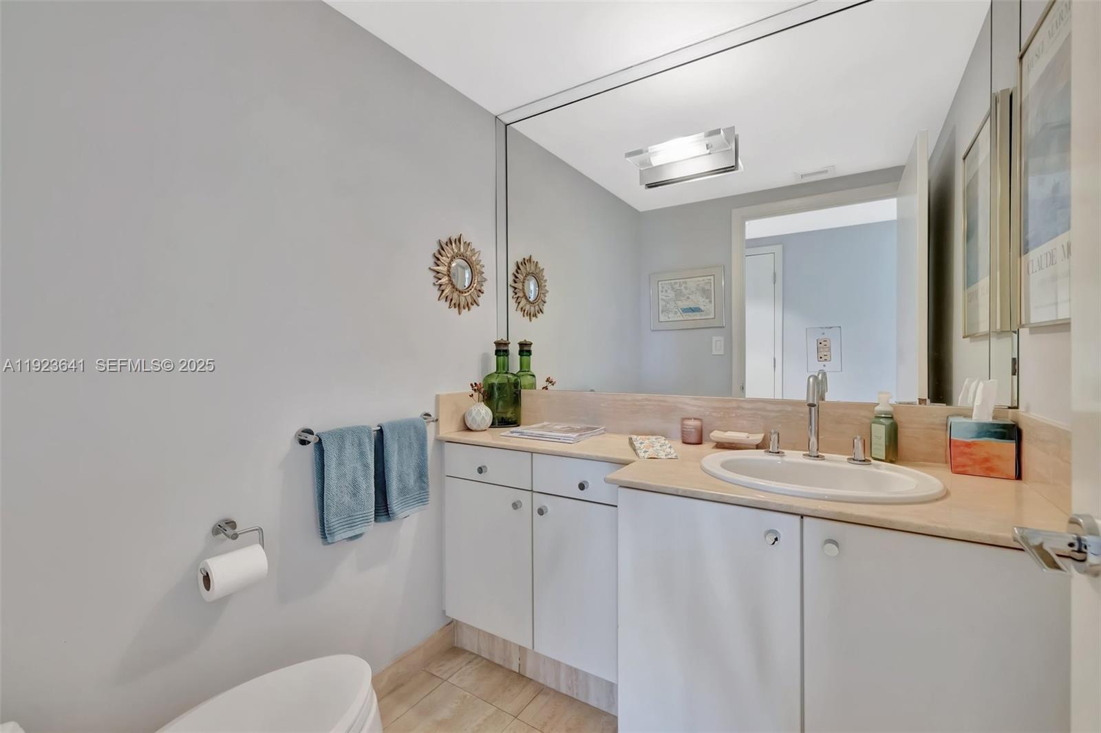 7000 Island Boulevard, Unit 1701 Aventura, FL 33160 - Photo 14 of 65 a bathroom with a granite countertop sink mirror and toilet