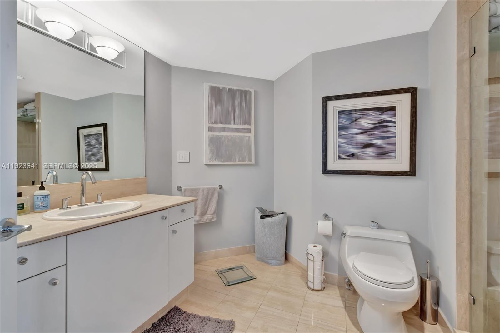 7000 Island Boulevard, Unit 1701 Aventura, FL 33160 - Photo 24 of 65 a bathroom with a toilet a sink and mirror
