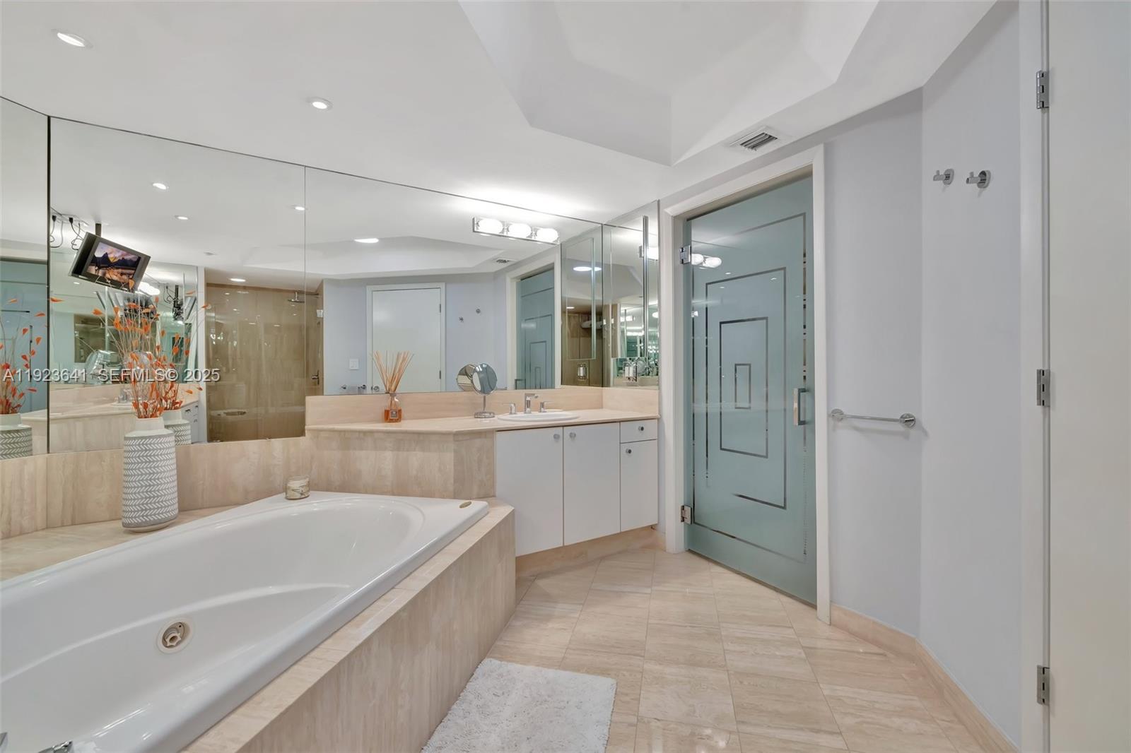 7000 Island Boulevard, Unit 1701 Aventura, FL 33160 - Photo 29 of 65 a bathroom with a bathtub shower sink and mirror