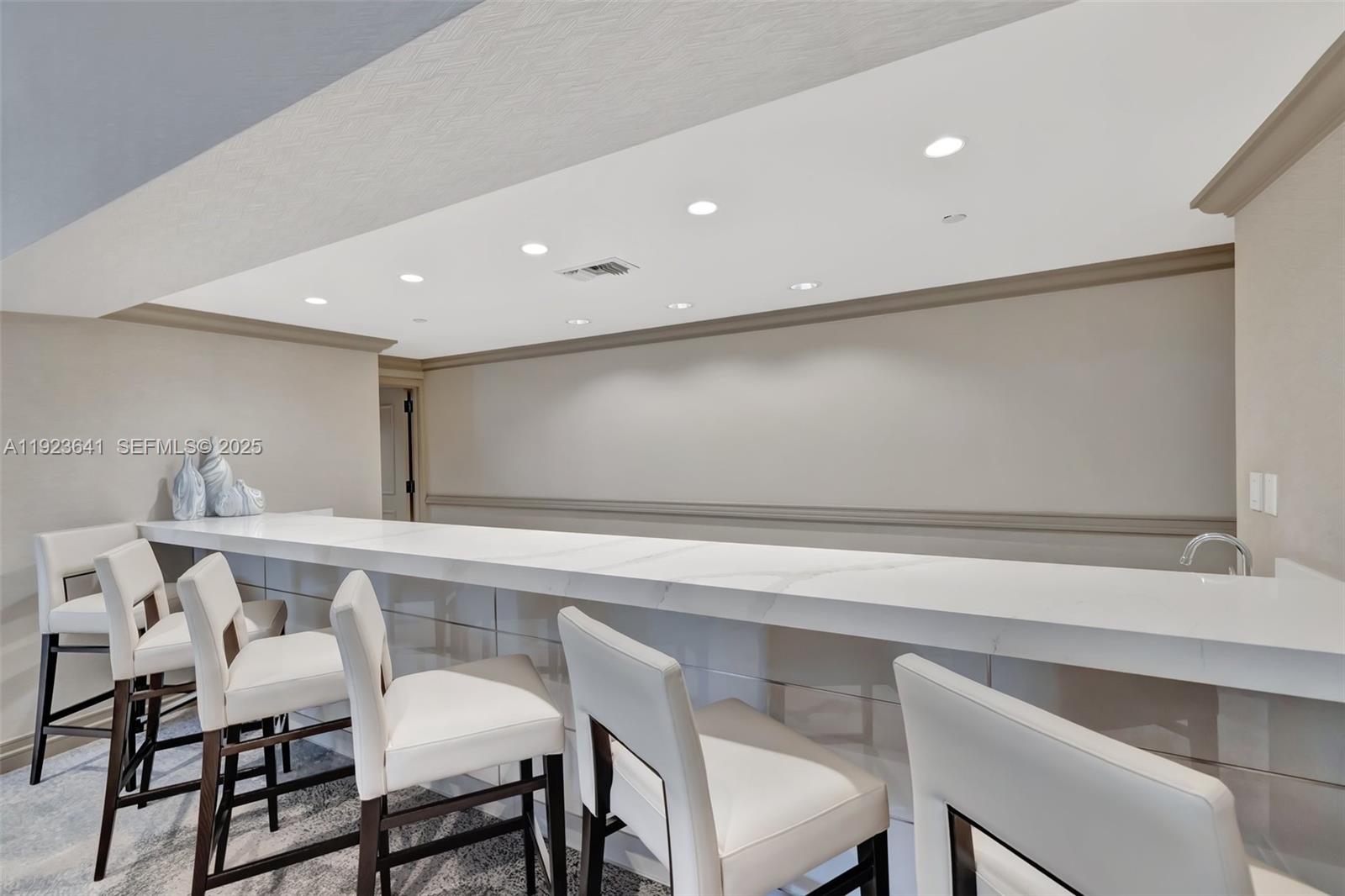 7000 Island Boulevard, Unit 1701 Aventura, FL 33160 - Photo 38 of 65 a kitchen with a dining table chairs and white cabinets