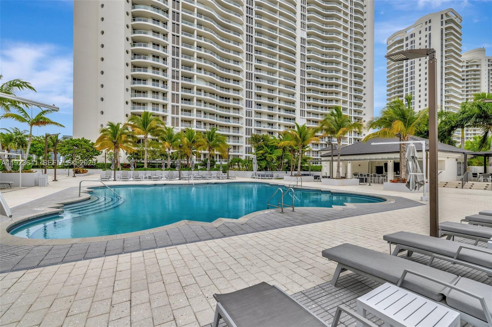 7000 Island Boulevard, Unit 1701 Aventura, FL 33160 - Photo 49 of 65 a view of a swimming pool with outdoor seating