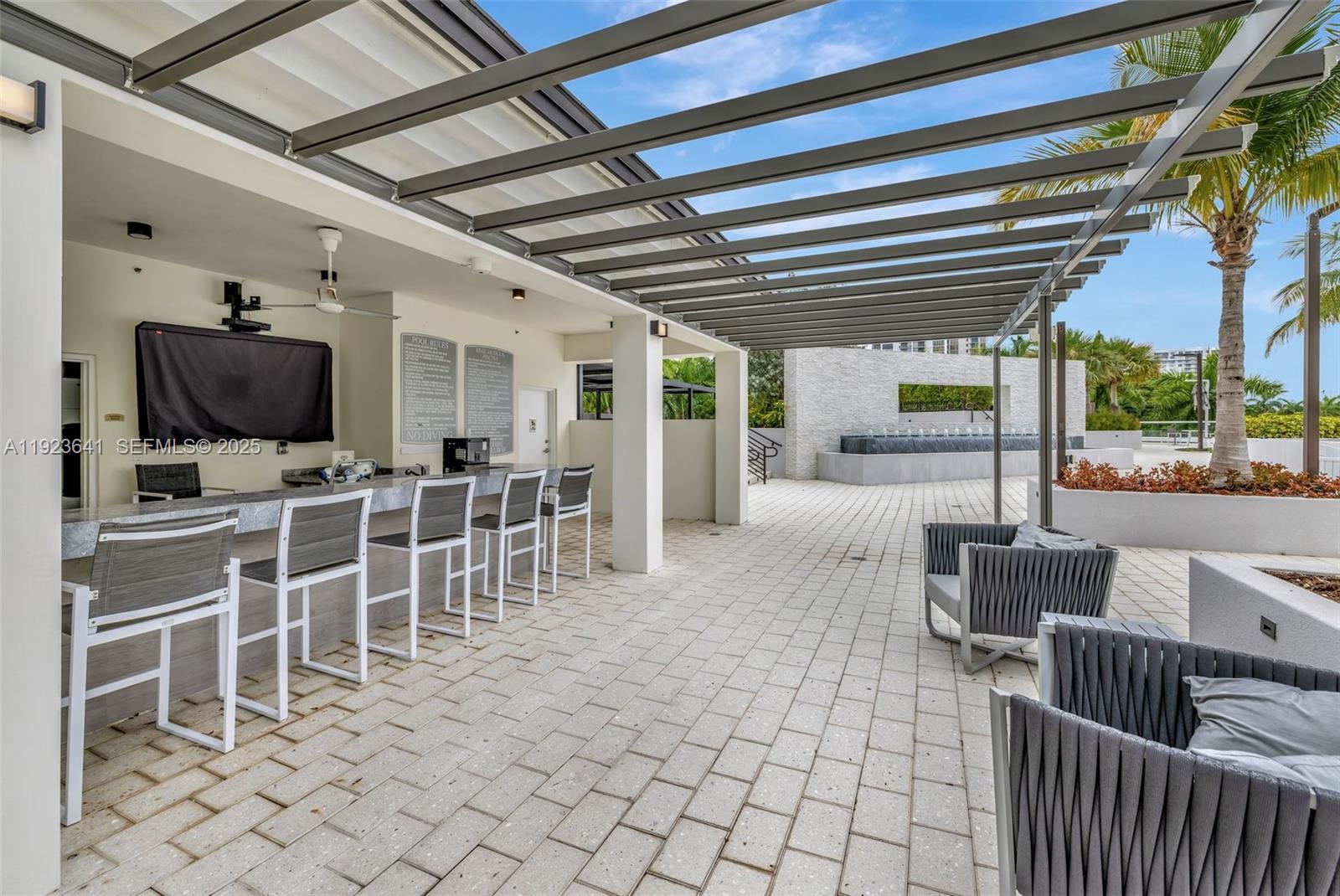 7000 Island Boulevard, Unit 1701 Aventura, FL 33160 - Photo 52 of 65 a living room with furniture a flat screen tv and outdoor space