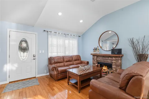a living room with furniture a rug a fireplace and a window