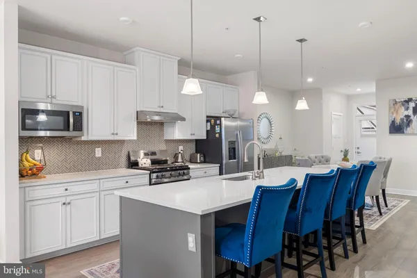 a kitchen with a dining table chairs sink and cabinets