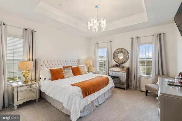 a spacious bedroom with a bed a window and a chandelier