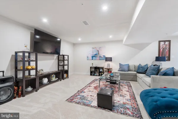 a living room with furniture and a flat screen tv with kitchen view