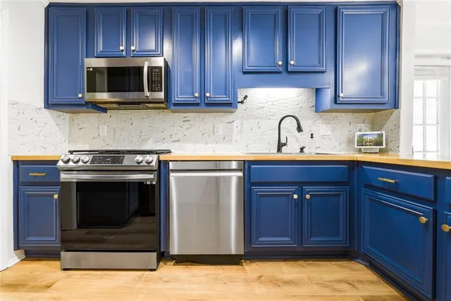a kitchen with granite countertop wooden cabinets and stainless steel appliances