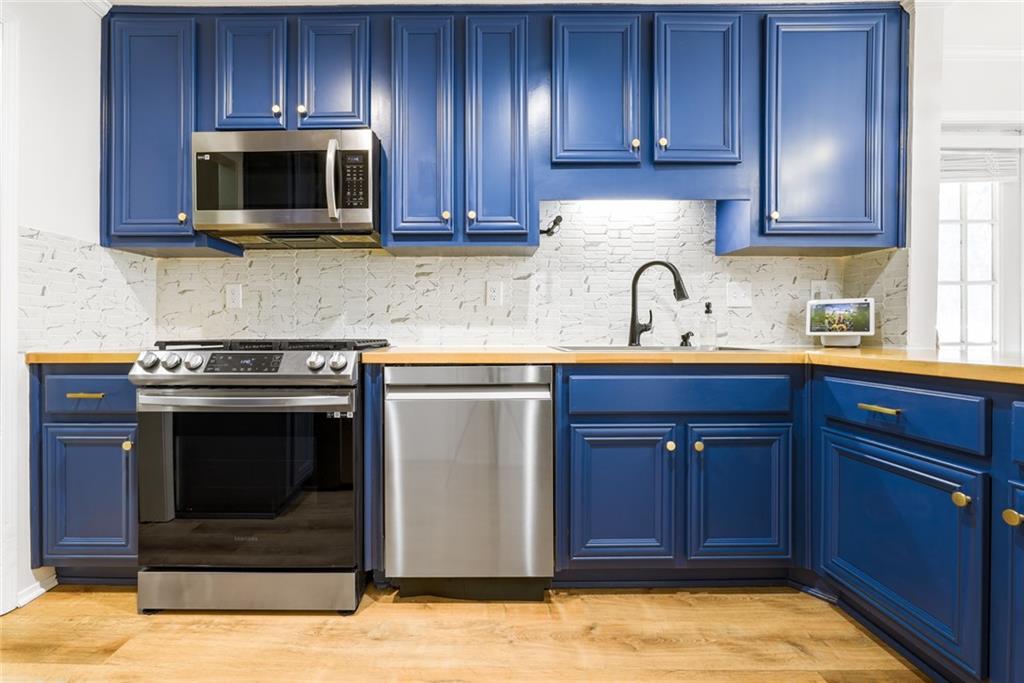 404 Countryside Place Smyrna, GA 30080 - Photo 13 of 36 a kitchen with granite countertop wooden cabinets and stainless steel appliances